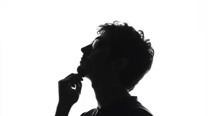 未来を見つめ思案する男性のシルエット。白い背景に、顎に手を当てて上方を見上げ、未来やアイデアについて思案する男性の横顔のシルエット画像です。